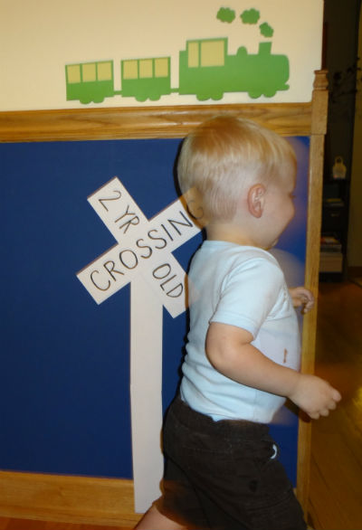 2 yr old running by 2 year old crossing sign