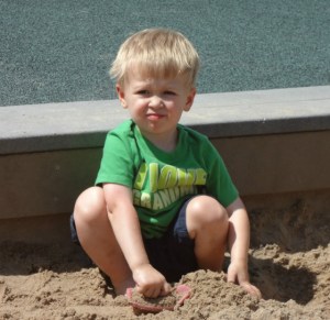 little brother playing in the sand